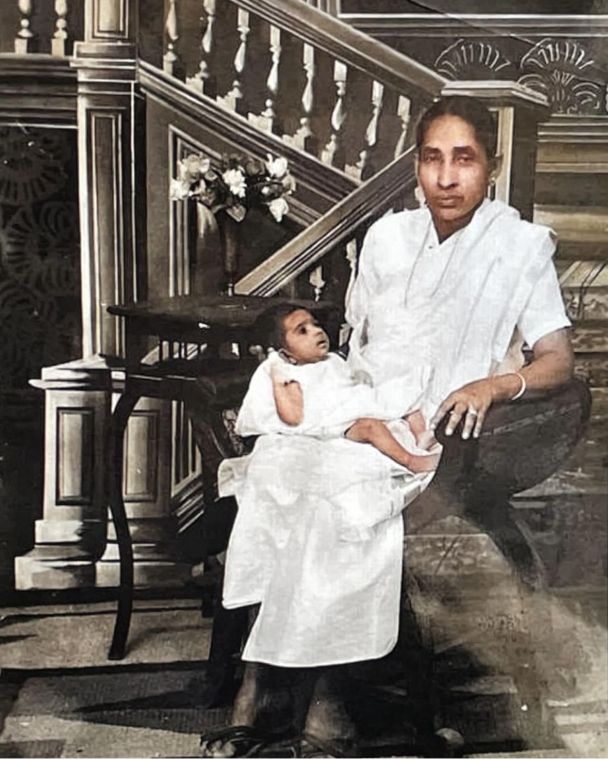 A studio photograph of Grace's grandmother in white Kerala dress, holding Grace as a month-old baby.